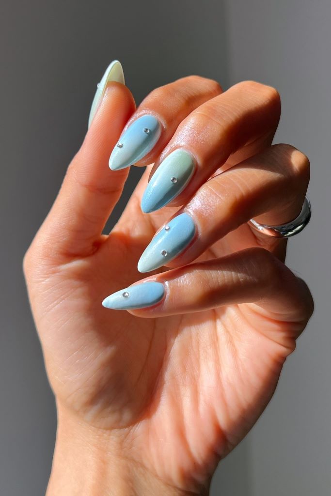 Zartes Blau Ombre Nageldesign mit dezenten Strasssteinen.